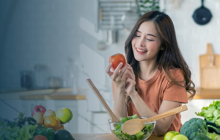 A woman preparing fresh produce at a kitchen counter