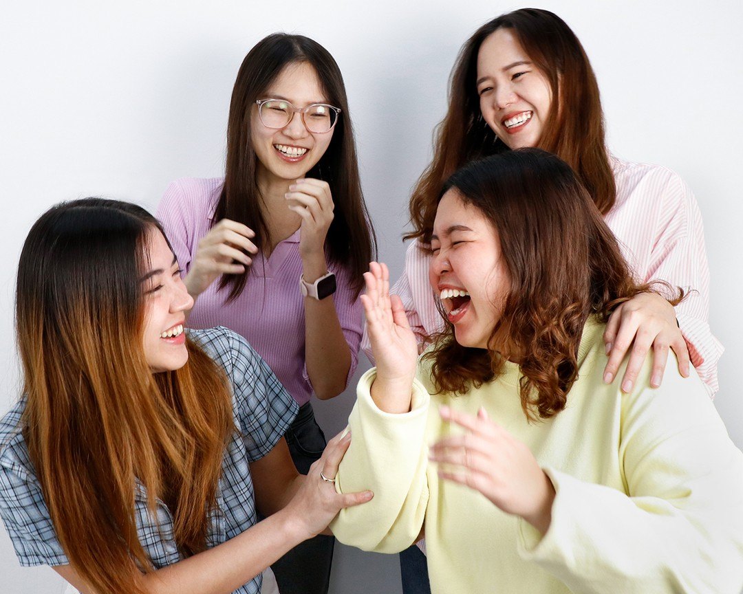 Four Primal colleagues laughing and applauding together
