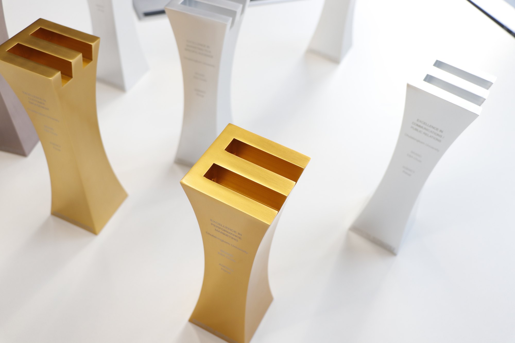 Gold and silver Primal industry award trophies on a white surface