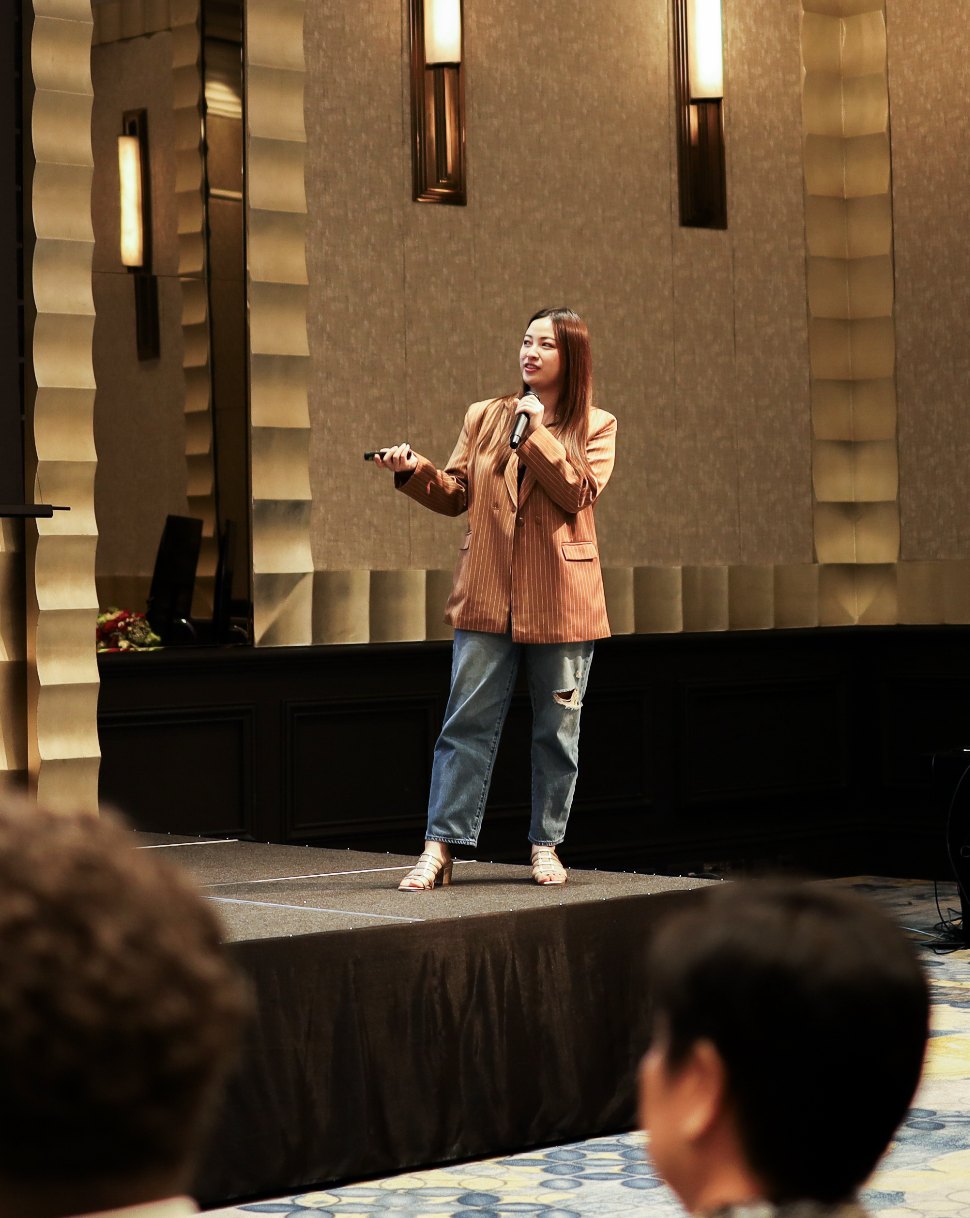 A Primal speaker presenting on stage to a seated audience