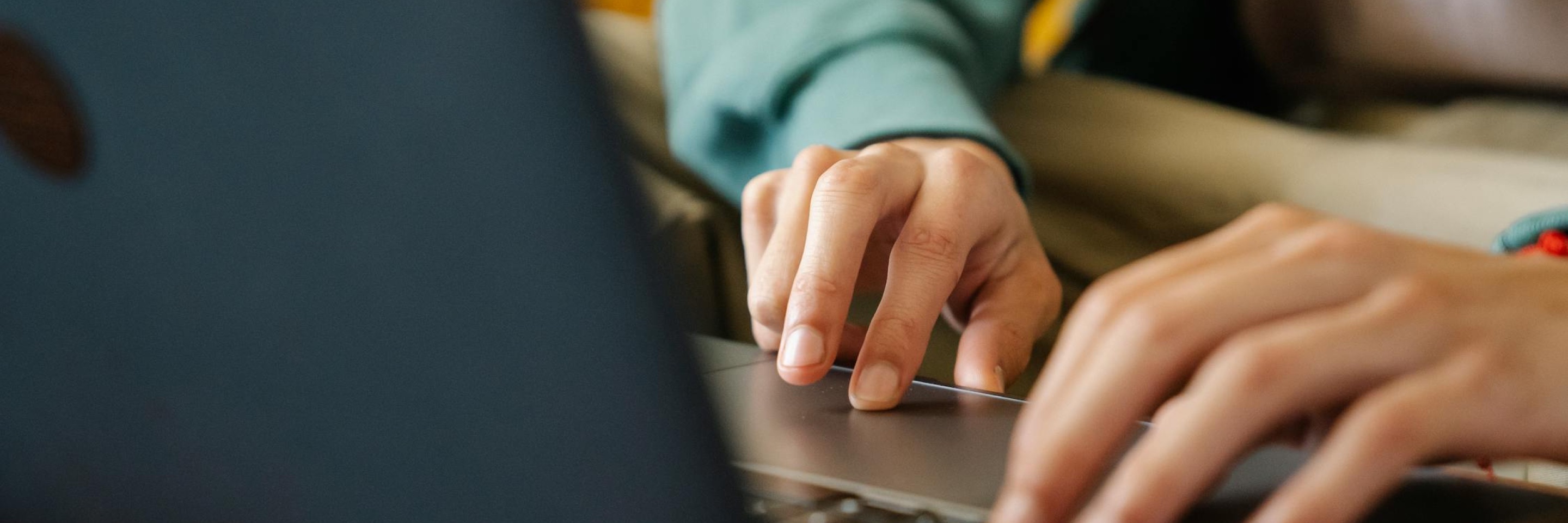 Hands on a laptop trackpad